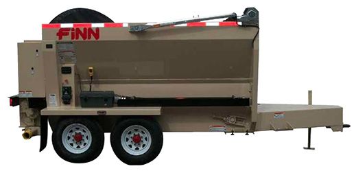 A side view of a tan Finn brand industrial hydroseeder trailer on a white background.