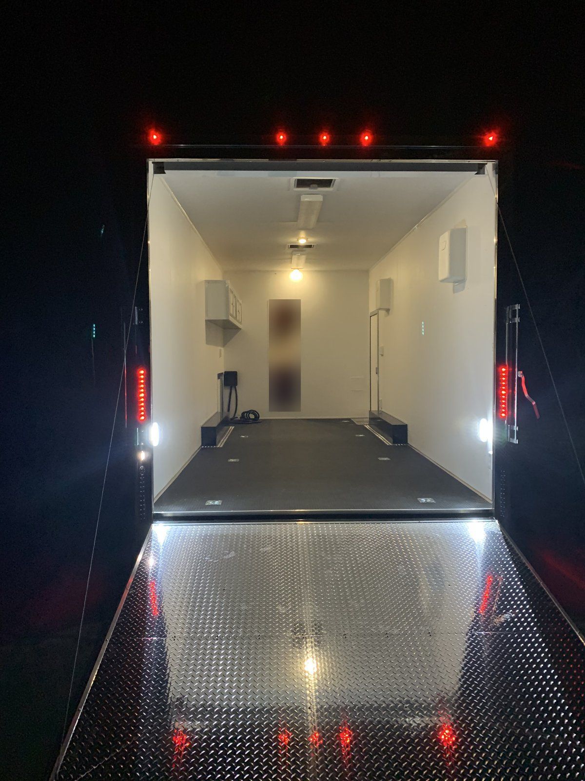 Lit garage and diamond-plate ramp door inside the Vintage Outlaw RVT trailer
