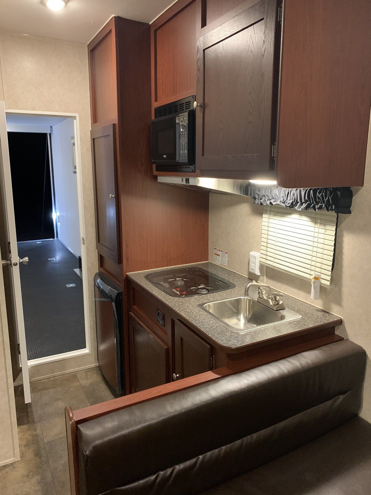Kitchenette with microwave, cooktop and sink in the Vintage Outlaw RVT trailer