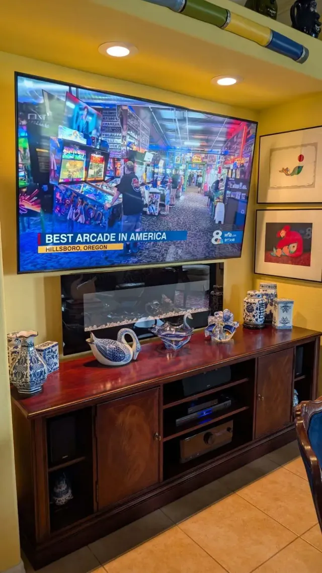 A flat screen tv is mounted to a wall next to a sound bar.