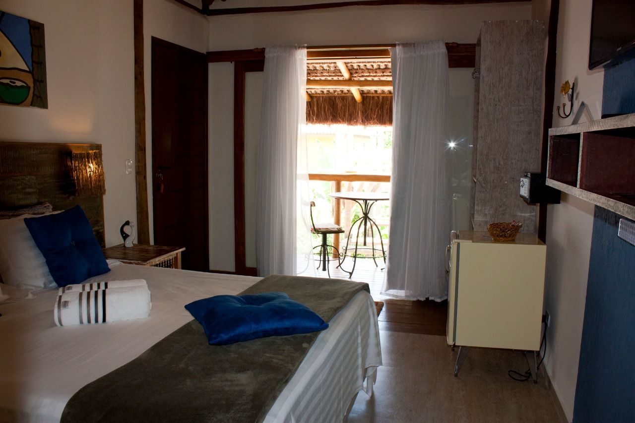 Um quarto com cama king size e varanda