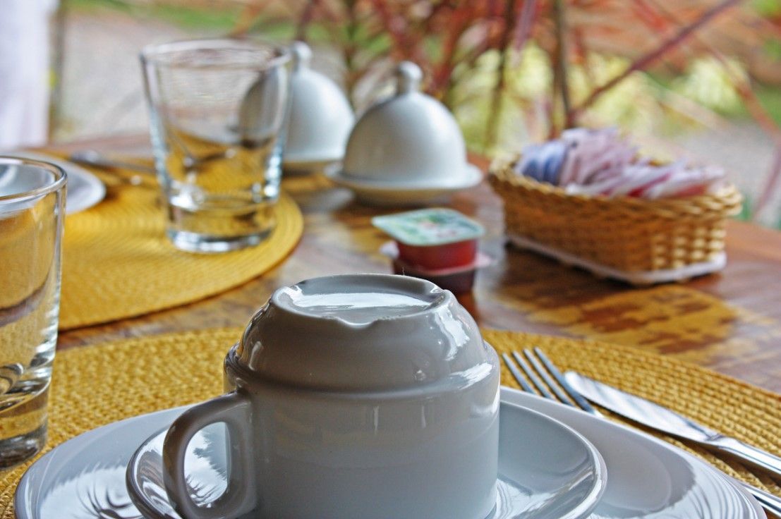 Uma xícara de café está sobre um pires sobre uma mesa.