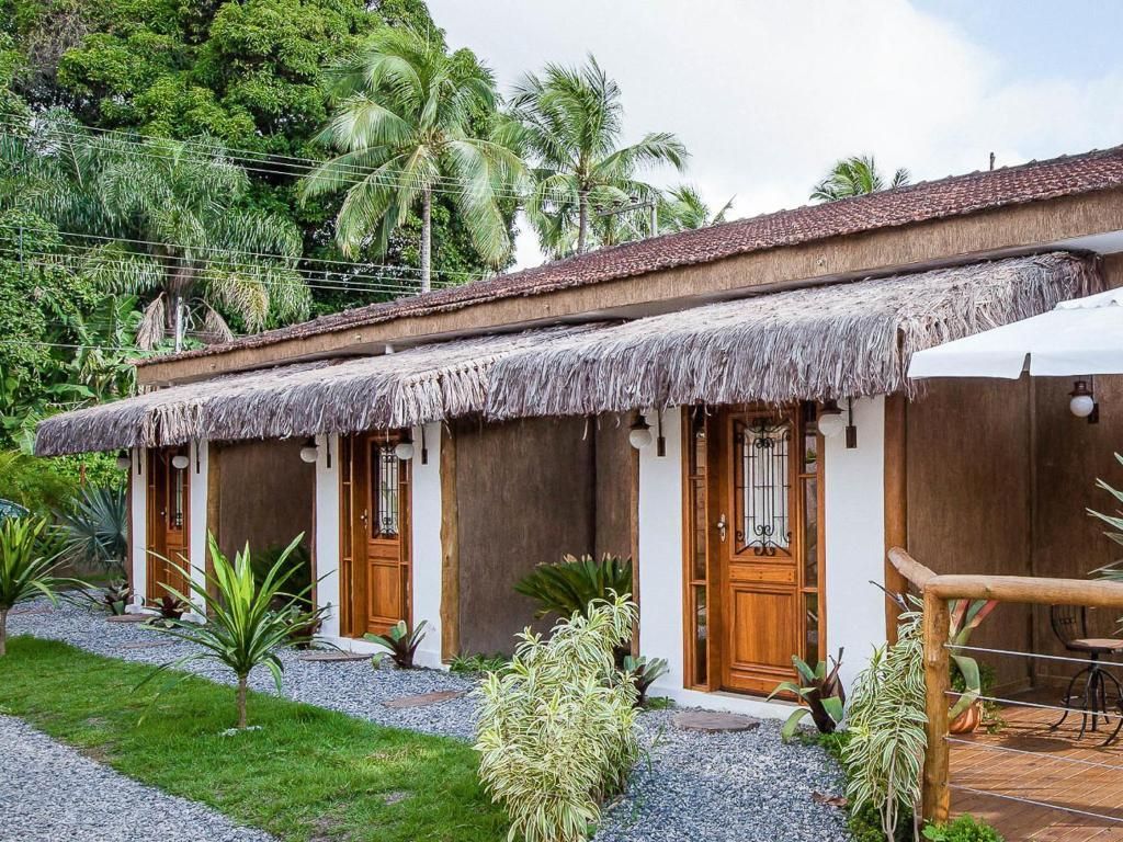 Uma fileira de pequenas casas com telhados de palha e portas de madeira.
