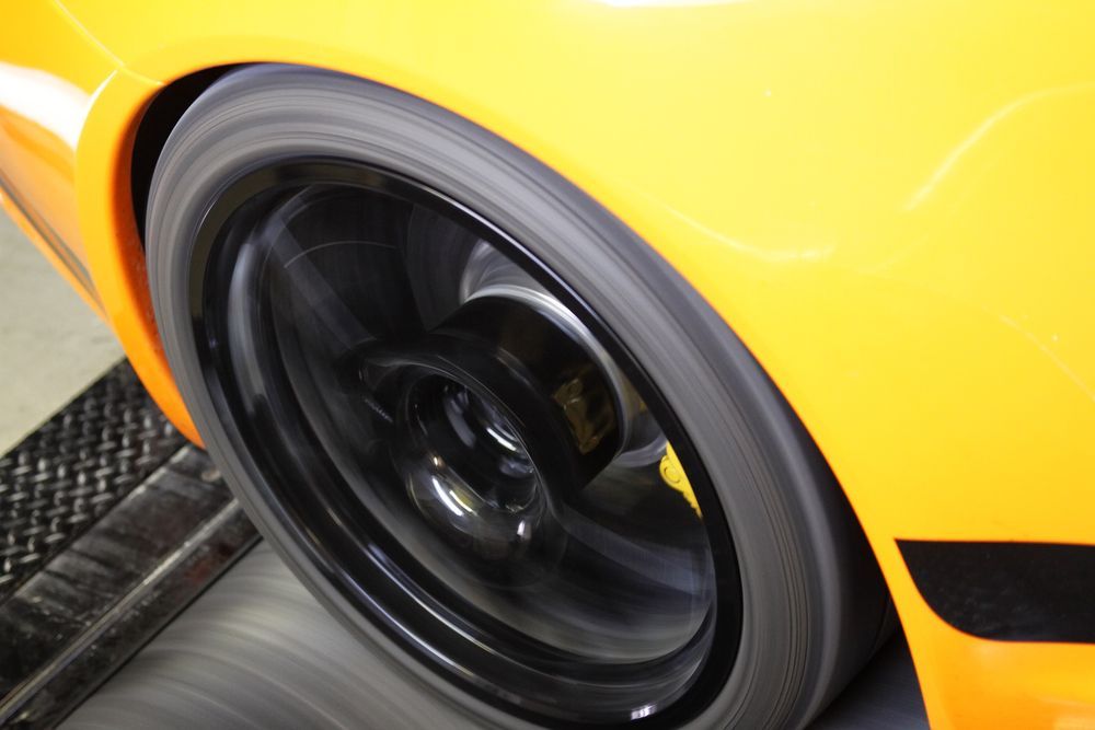 Rotating Black Car Tire on a Yellow Sports Car — EFI Evolutions Mechanical Repairs in Coffs Harbour, NSW