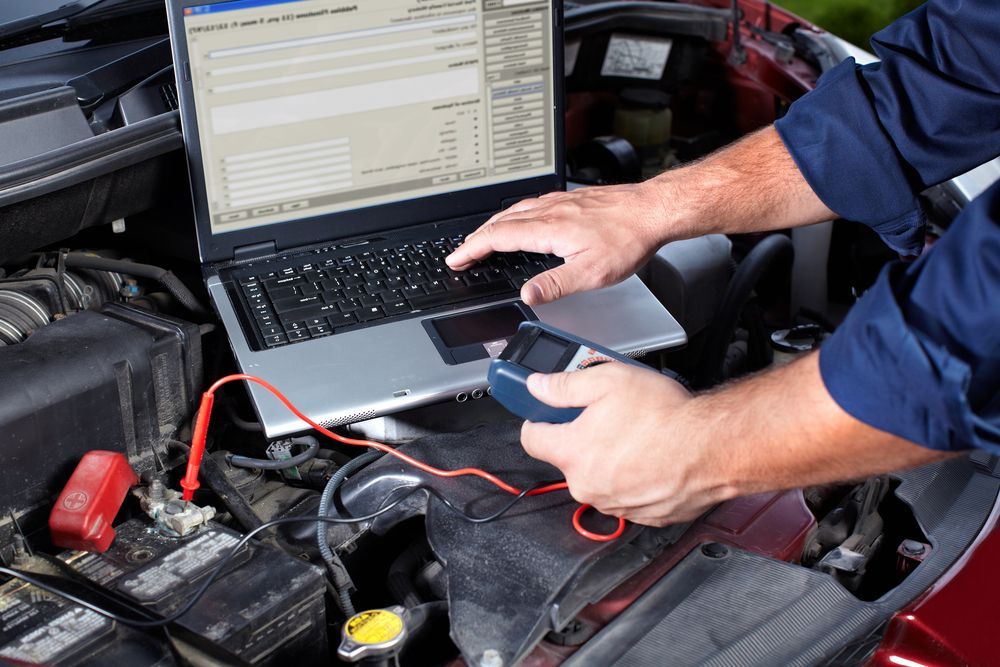 Mechanic Uses a Laptop and Diagnostic Tool on a Car Engine — EFI Evolutions Mechanical Repairs in Grafton, NSW