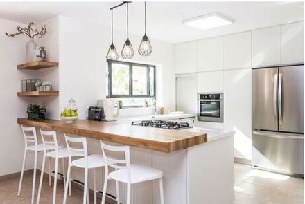Picture of a update and remodeled kitchen with white cabinets and new stainless steel appliances.