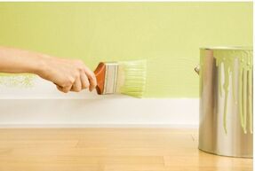 Handyman painter picture of a wall being painted green using a paint brush.