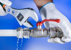 Richmond Handyman using a wrench to tighten a sink pipe.