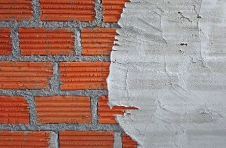 Picture of a structural repair to a foundation brick wall using grey troweled mortar.
