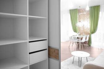 Picture of white storage cabinets and a walk in closet for additional storage.