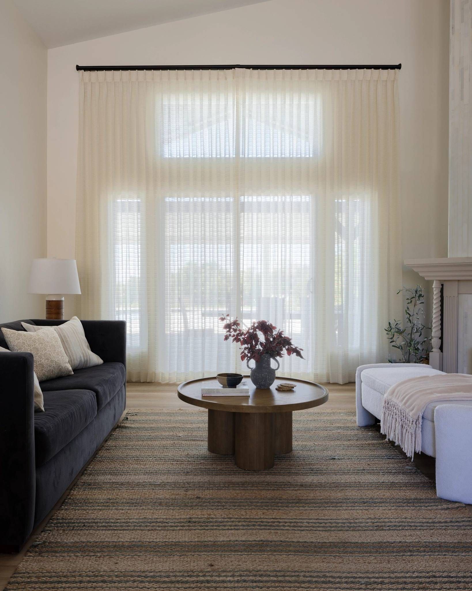 Custom drapery with coordinating hardware on an expansive window in a chic living room