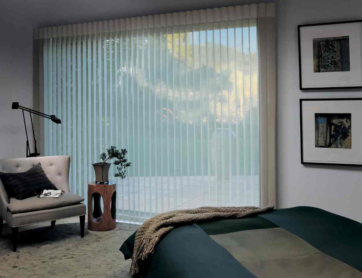 A luxurious bedroom with sheer shadings on the large window overlooking a patio surrounded by greenery at Curtain Concepts near Huntington, WV