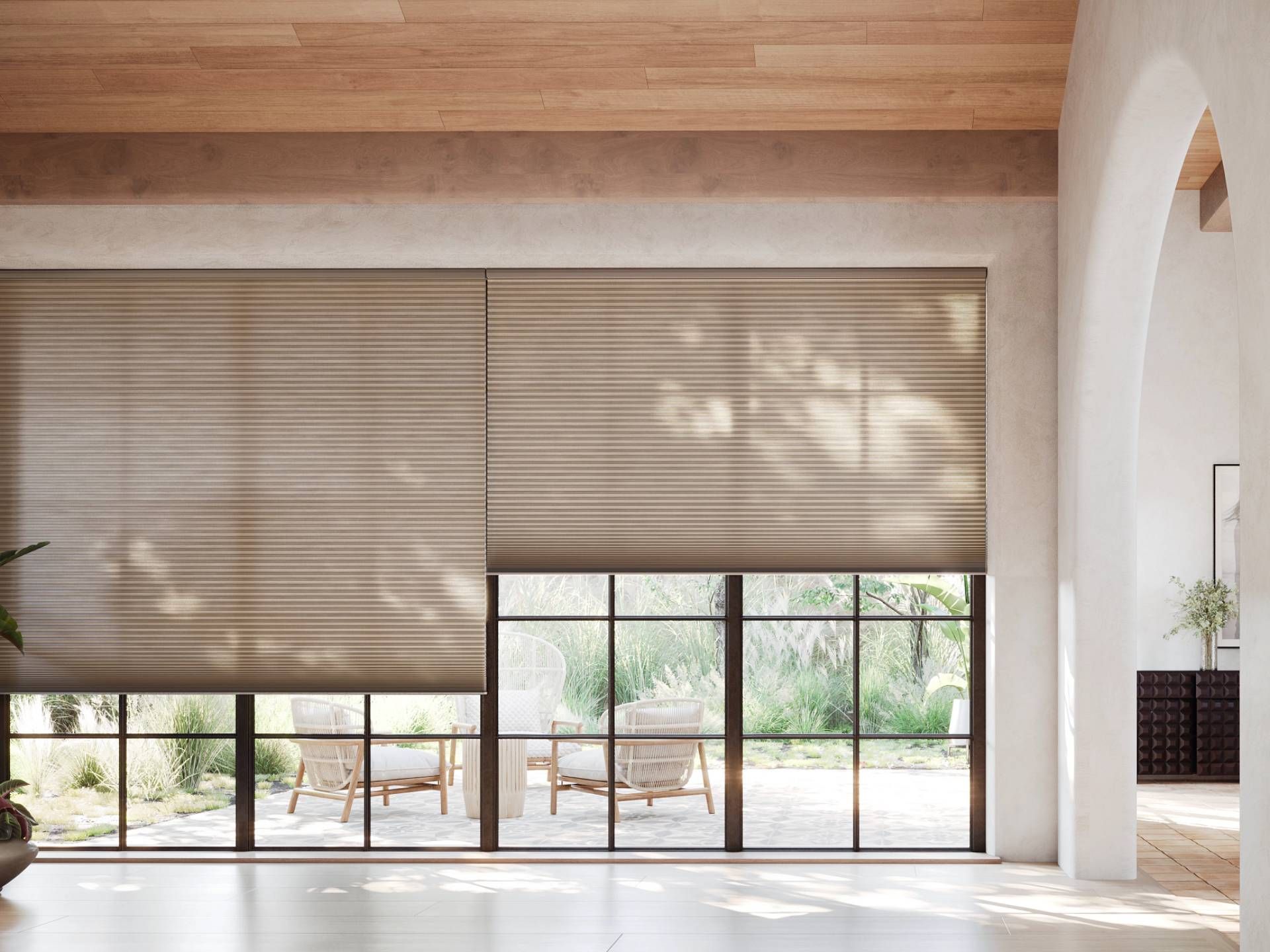 Hunter Douglas Duette® Cellular Shades on large windows in a home, leading out to a patio