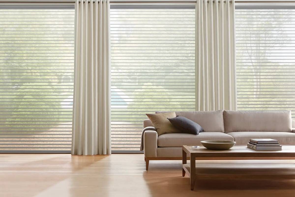 Hunter Douglas Nantucket™ Sheer Shades in a neutral color on large windows paired with drapery