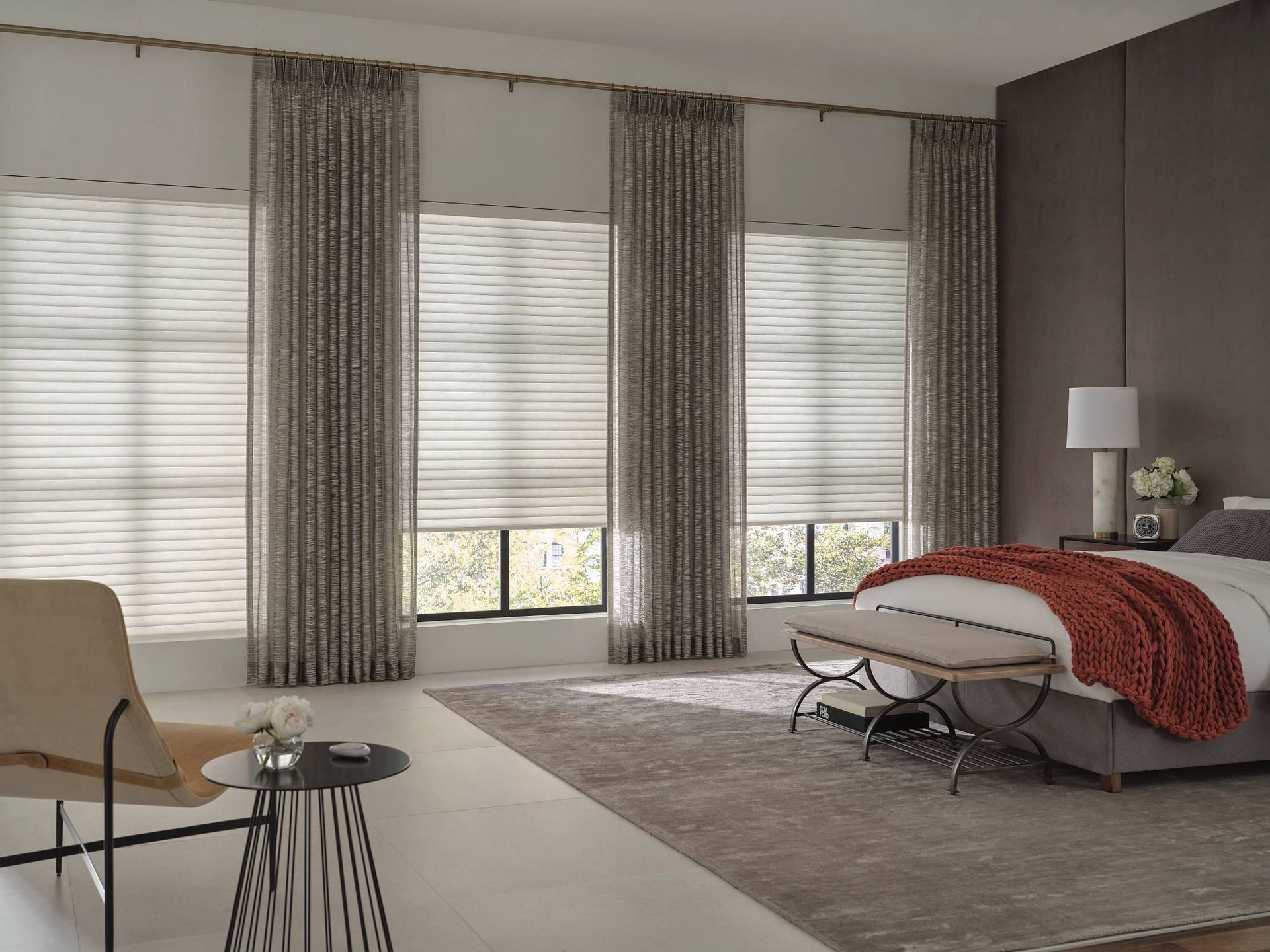Hunter Douglas Sonnette® Cellular Roller Shades, partially shut, on three windows in a cozy bedroom