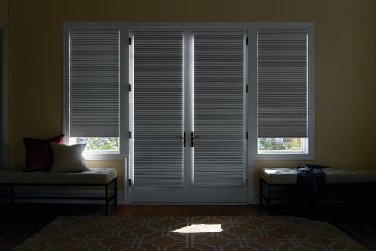 Living room with doors and windows equipped with room-darkening Hunter Douglas Duette® Cellular Shades near Huntington, WV