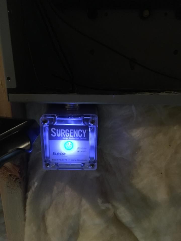 Blue-lit emergency alert box on a wall, glowing in a dim room.