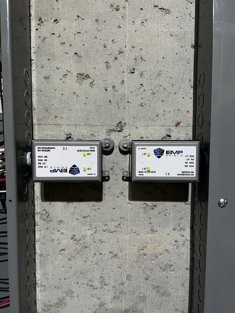 Two white utility meters mounted on a gray concrete wall inside an industrial space