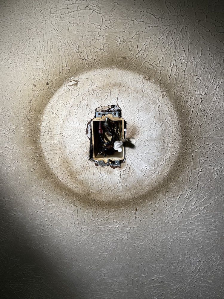Close-up of a recessed ceiling light socket with exposed wiring and a missing bulb cover