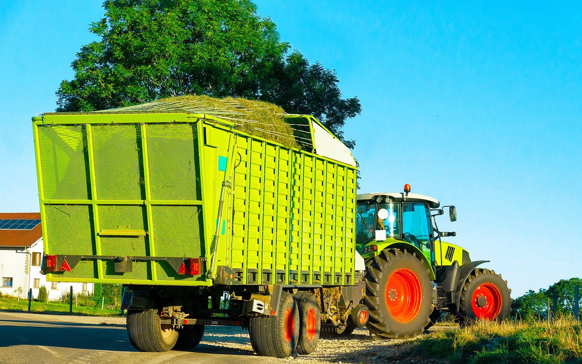 Agricultural Tractor with Trailer in Road — Garfield, GA — Southeast Soft Wash Solutions Agricultural Tractor with Trailer in Road — Garfield, GA — Southeast Soft Wash Solutions
