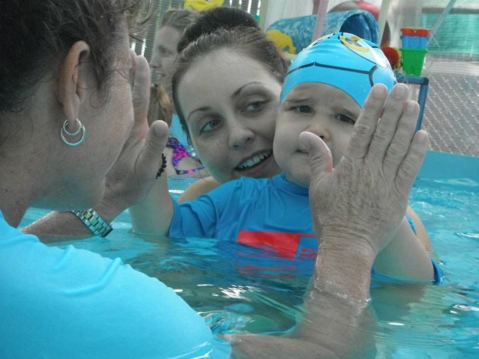 A Woman is Holding a Baby in a Swimming Pool — Affinity Swim in Norman Gardens, NSW