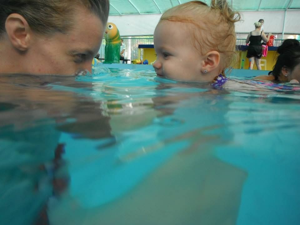 A Woman is Holding a Baby in a Swimming Pool — Affinity Swim in Norman Gardens, NSW