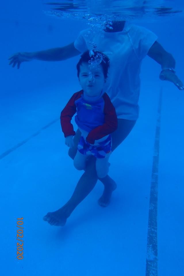 A Woman is Holding a Child Underwater in a Swimming Pool — Affinity Swim in Norman Gardens, NSW