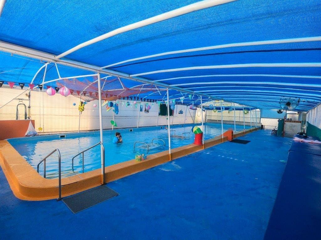 A Large Indoor Swimming Pool With a Blue Canopy Over It — Affinity Swim in Norman Gardens, NSW