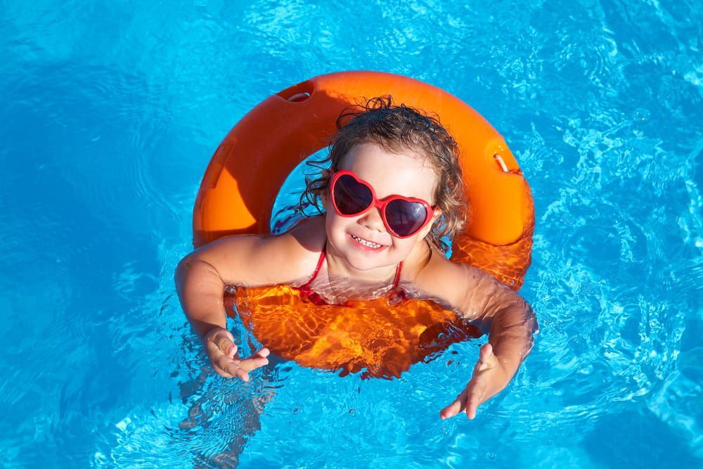 A Little Girl is Floating on an Orange Life Preserver in a Swimming Pool — Affinity Swim in Norman Gardens, NSW