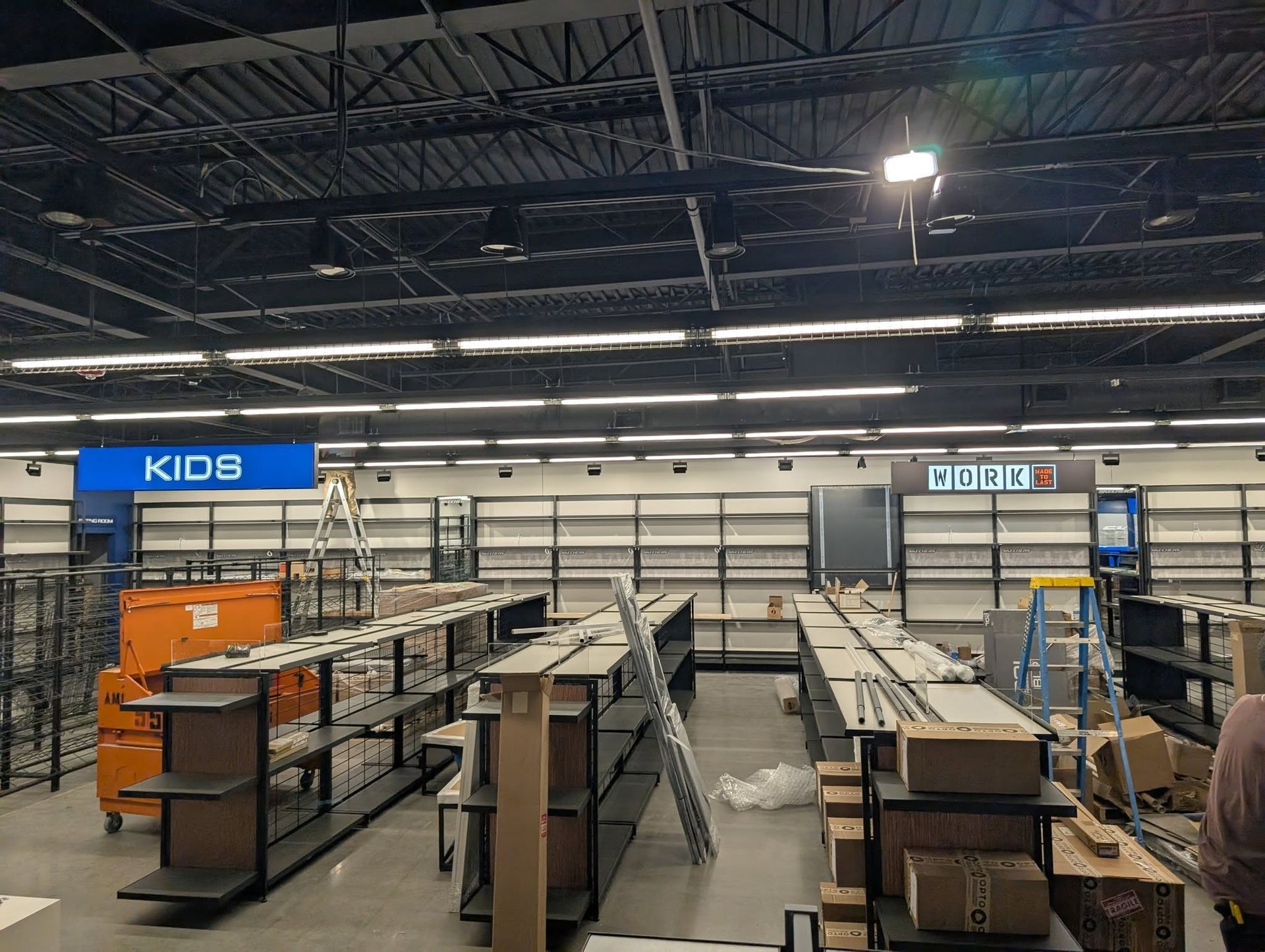 Empty store interior with shelving and construction materials.