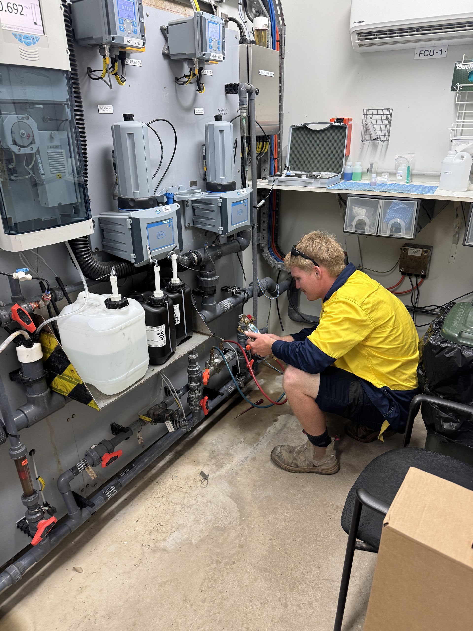 A Large White Water Heater is Sitting Outside of a House — Northern Plumbing In Mount Louisa, QLD