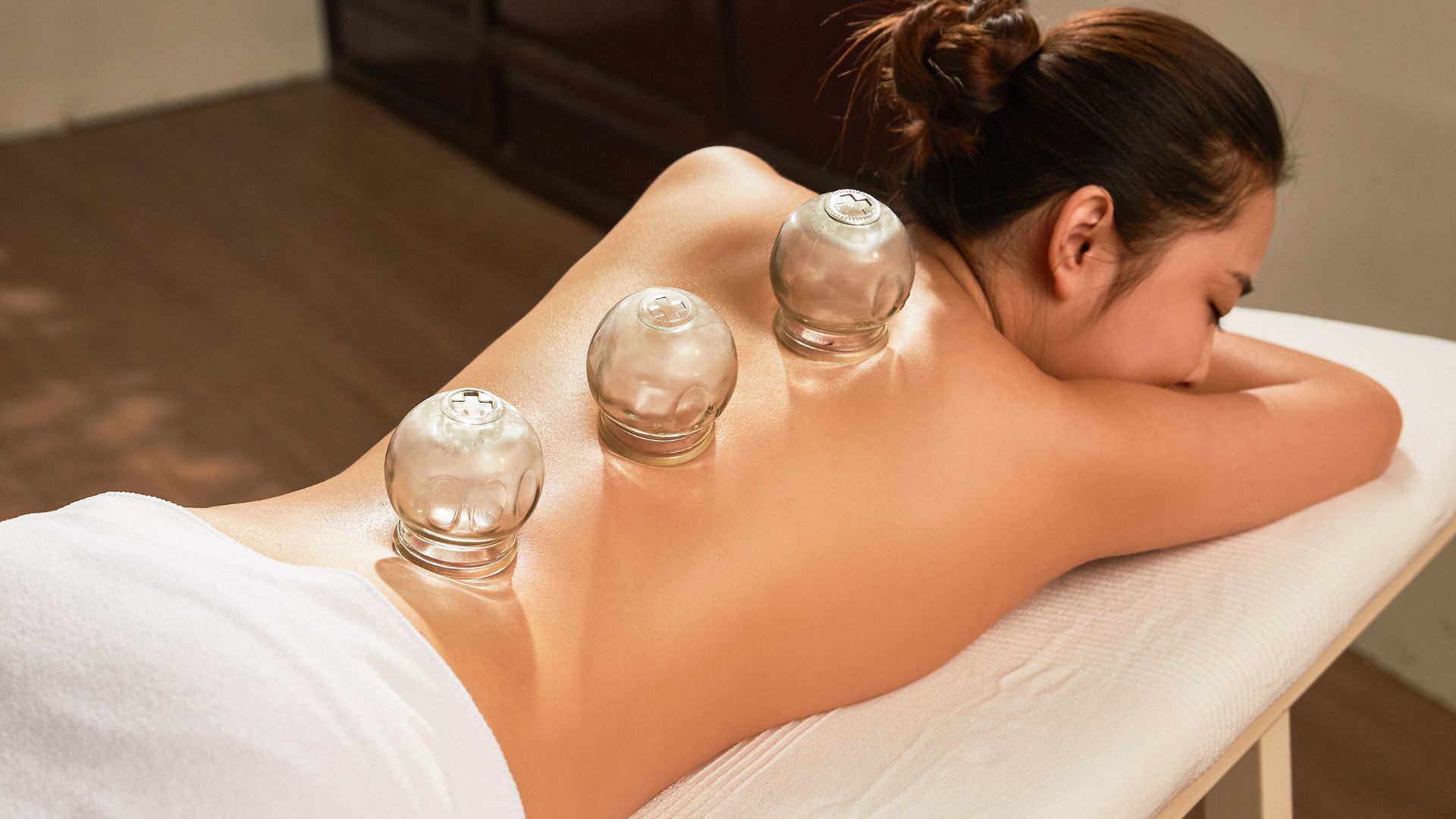 Person receiving hot stone massage on back at spa
