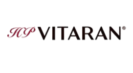 Vitaran logotips ar stilizētiem tumši sarkaniem iniciāļiem un melnu tekstu uz balta fona
