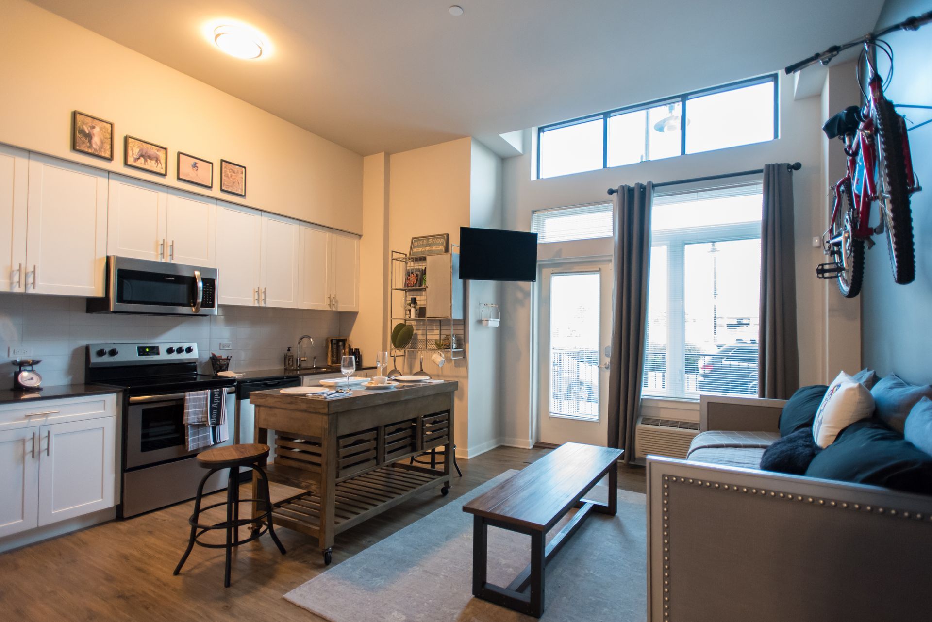 A living room and kitchen in a house with a couch and a table.