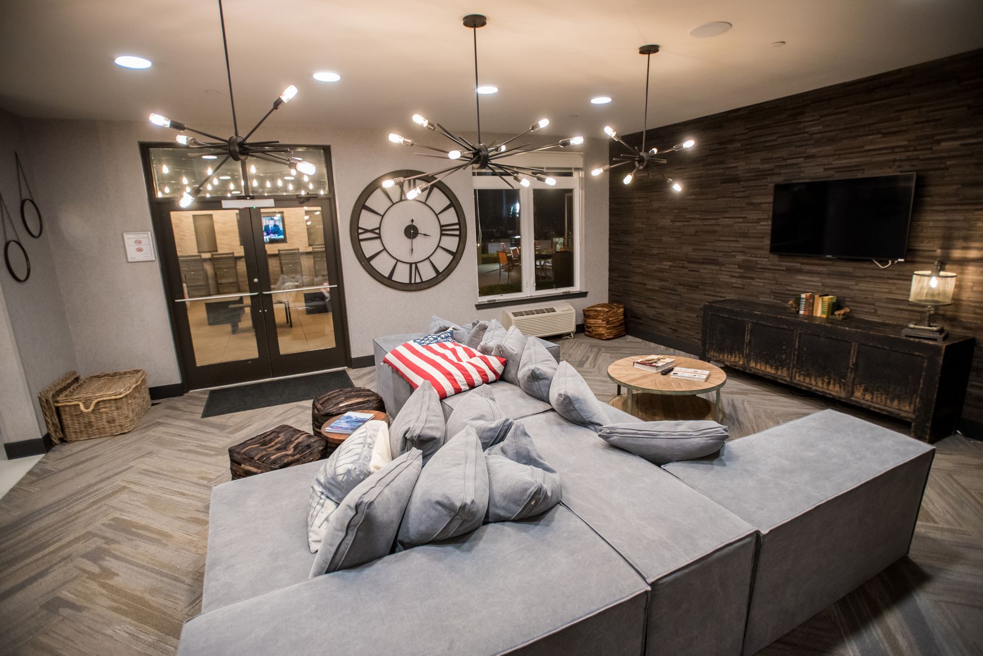 A living room with a couch and a clock on the wall.