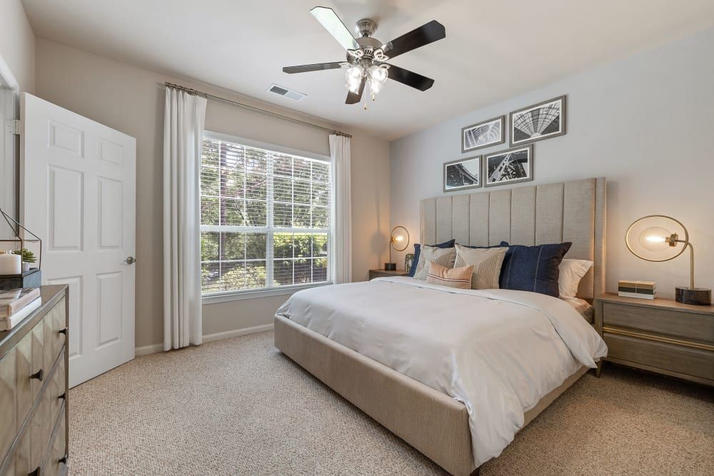 a bedroom with a large bed and a ceiling fan at Marquis  Carmel Commons in Charlotte, NC.