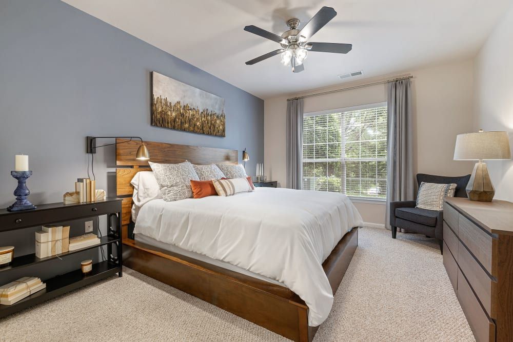 a bedroom with a large bed and a ceiling fan at Marquis Carmel Commons in Charlotte, NC.