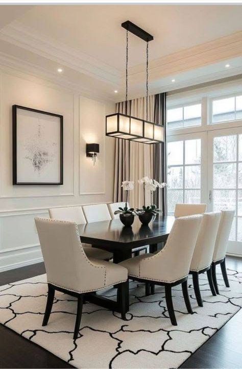 Elegant dining room with black table, cream chairs, and modern pendant light over a patterned rug