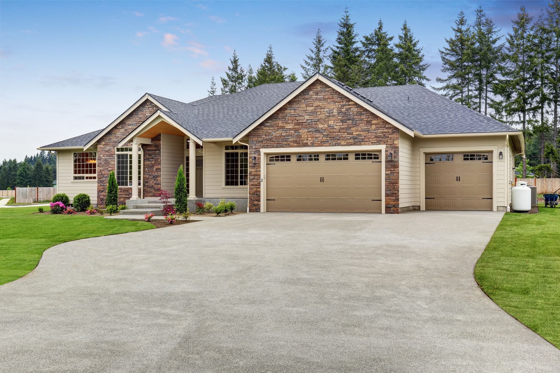 Single-story brick house with three garages, large driveway, and manicured lawn