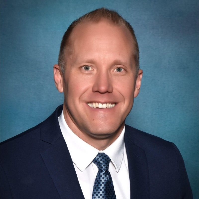 A man in a suit and tie is smiling for the camera.