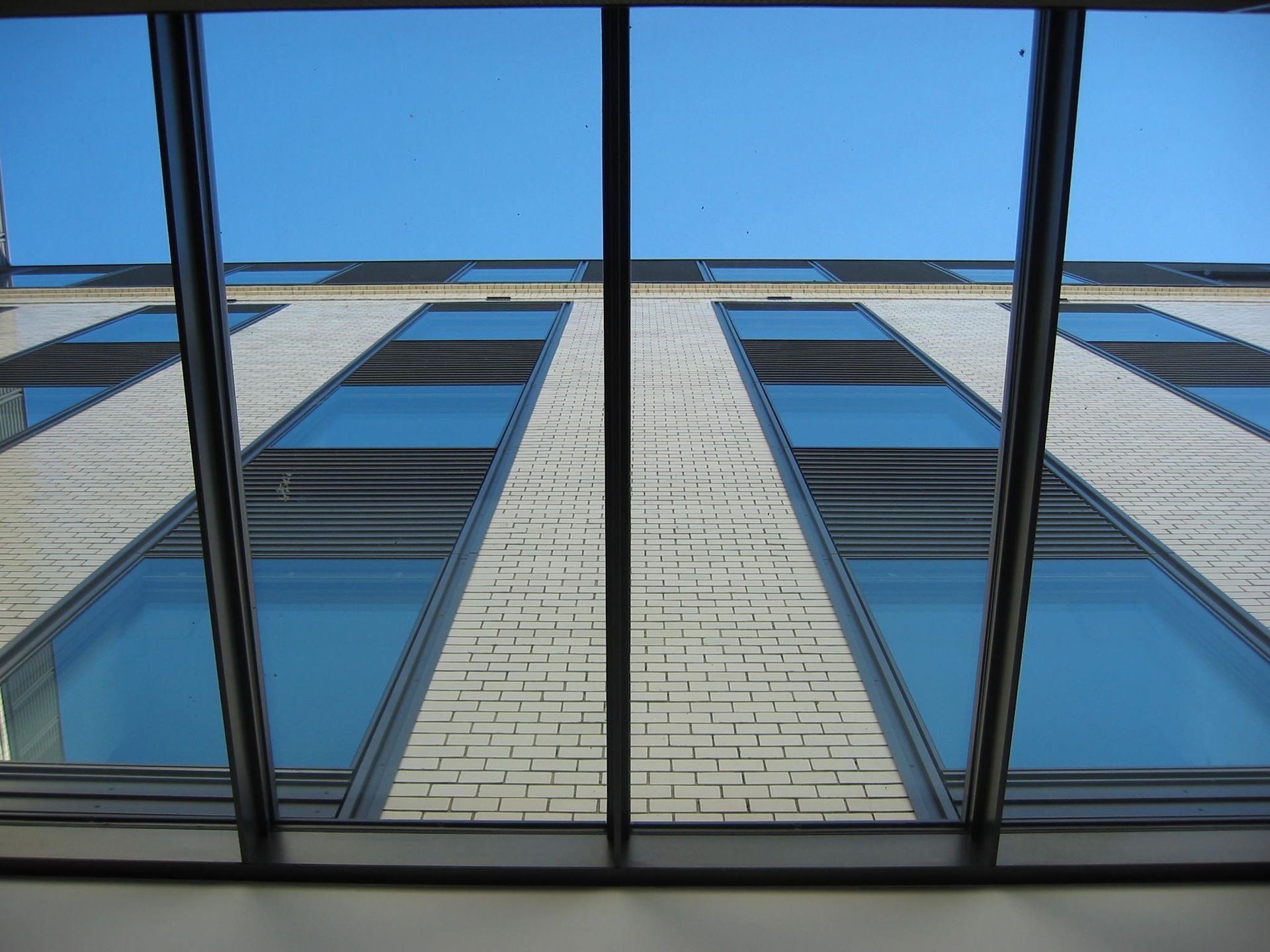 Blick nach oben auf ein Gebäude mit vielen Fenstern