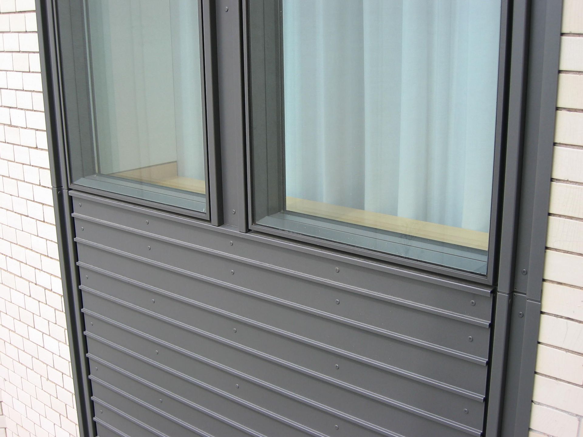 Ein Backsteingebäude mit einer schwarzen Verkleidung und einem Fenster