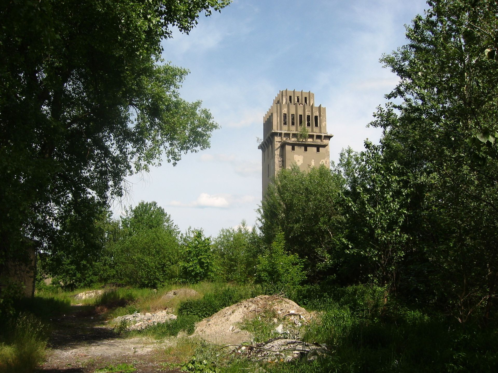 Ein sehr hohes Gebäude ist von Bäumen und Gras umgeben