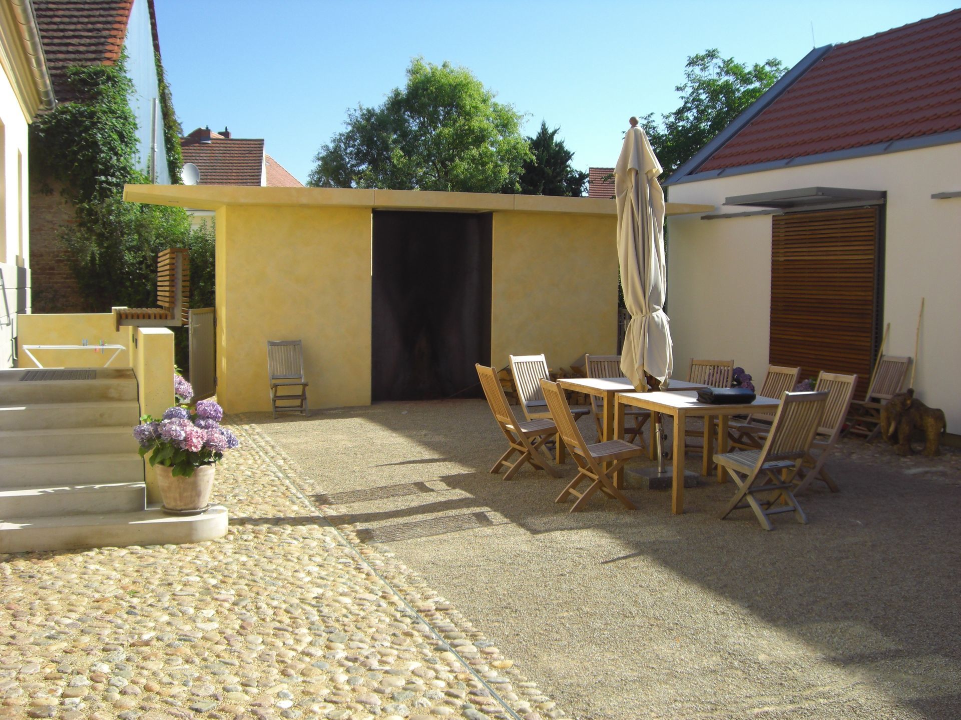 Eine Terrasse mit Tisch und Stühlen und einem Sonnenschirm