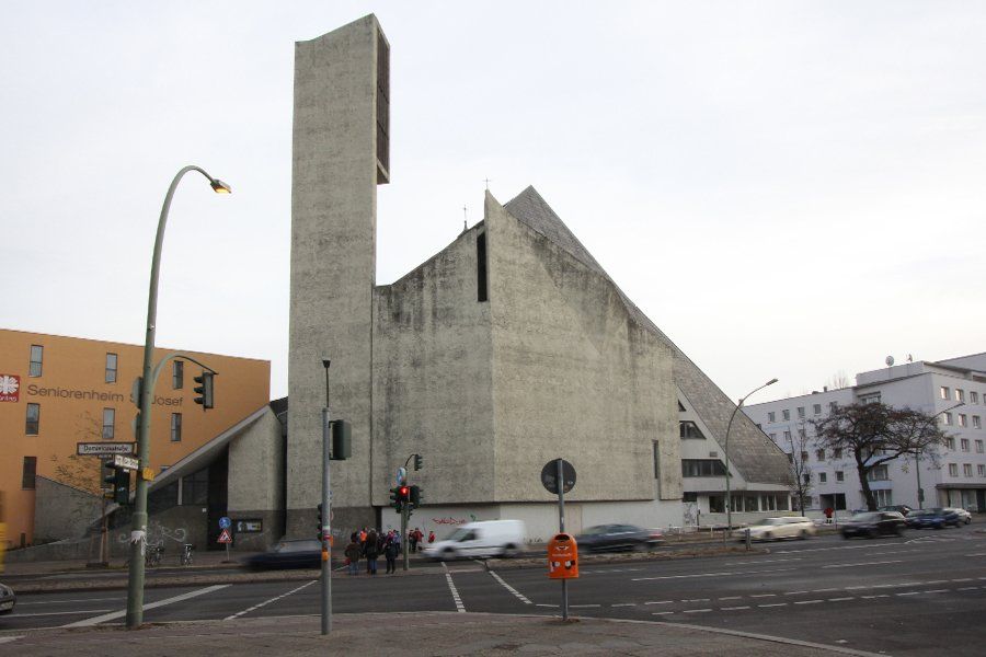 Ein großes Gebäude mit einem sehr hohen Turm steht mitten in einer Stadt
