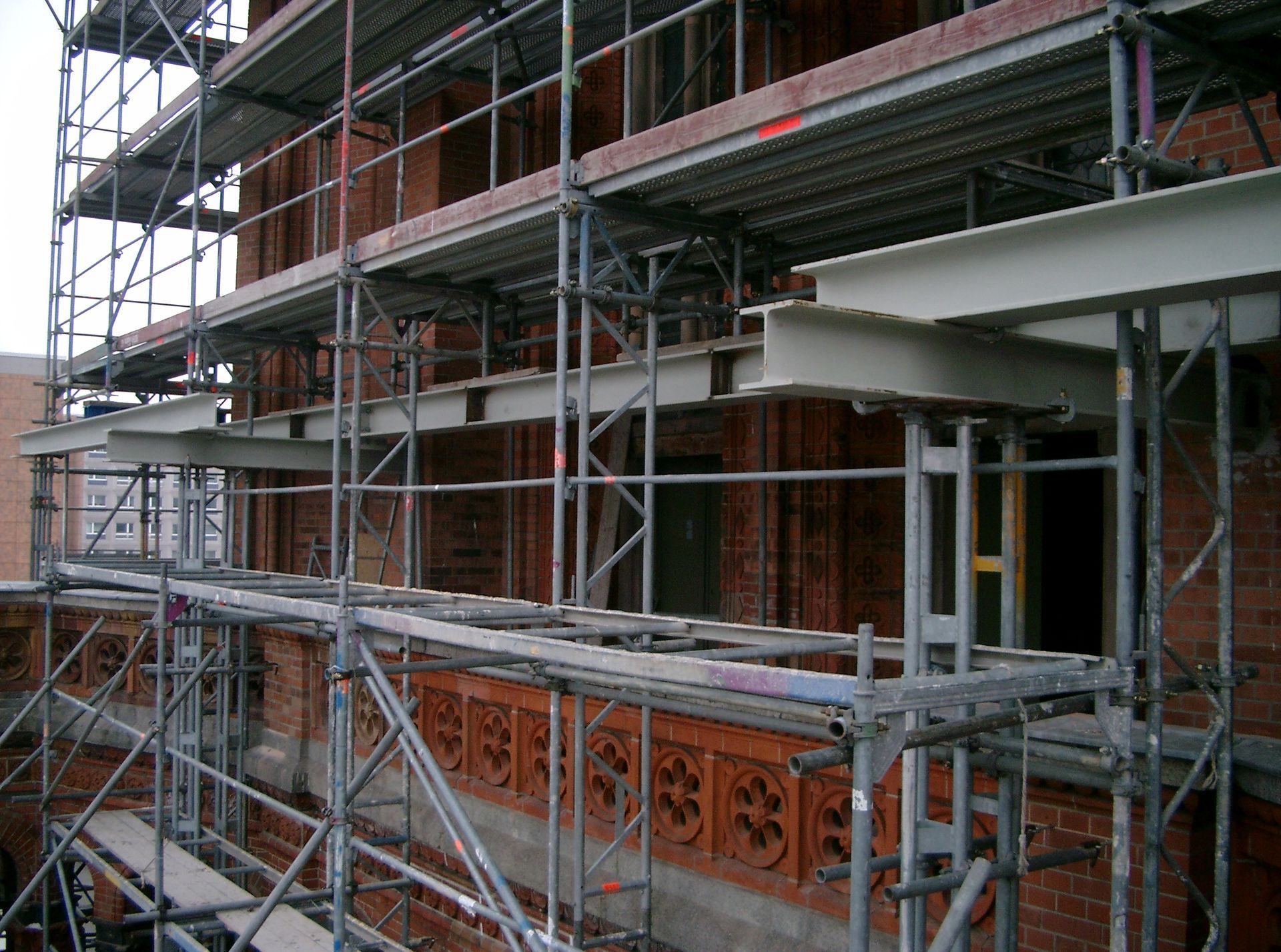 Ein Backsteingebäude wird mit Gerüsten drumherum gebaut