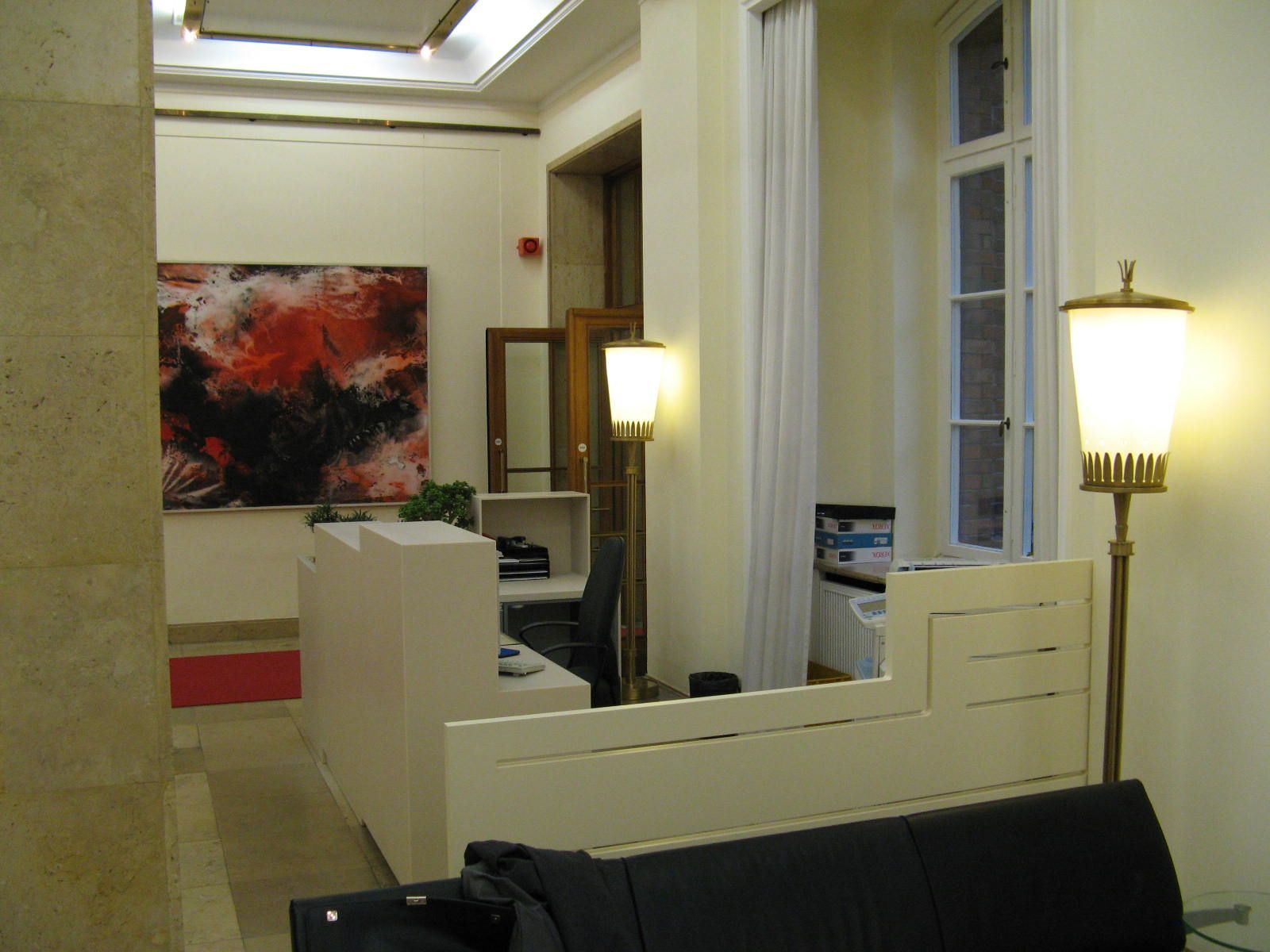 Ein Zimmer mit einem Sofa und einer Lampe und einem Gemälde an der Wand