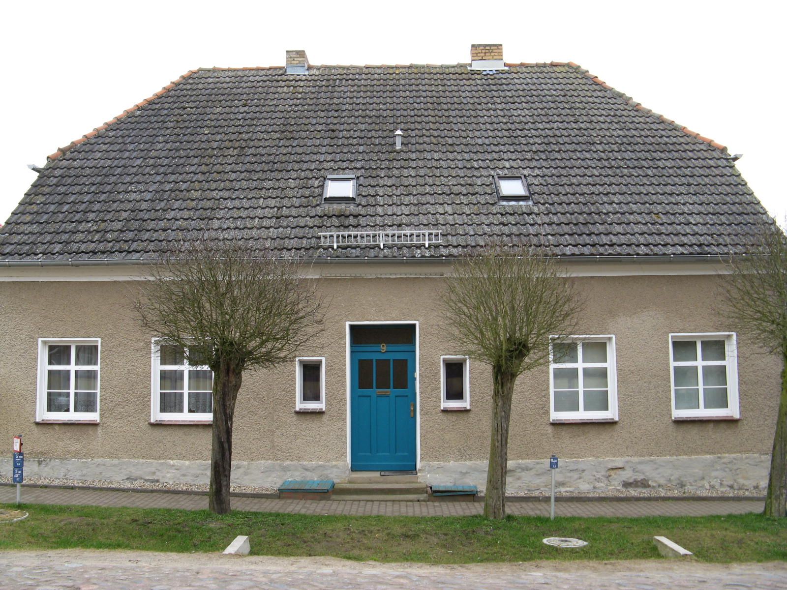 Ein Haus mit einer blauen Tür und weißen Fenstern