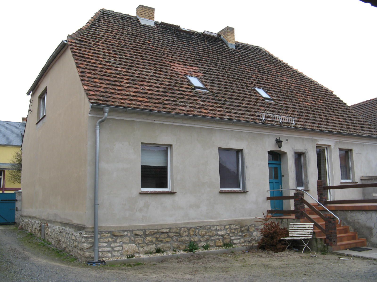 Ein Haus mit Ziegeldach und blauer Tür