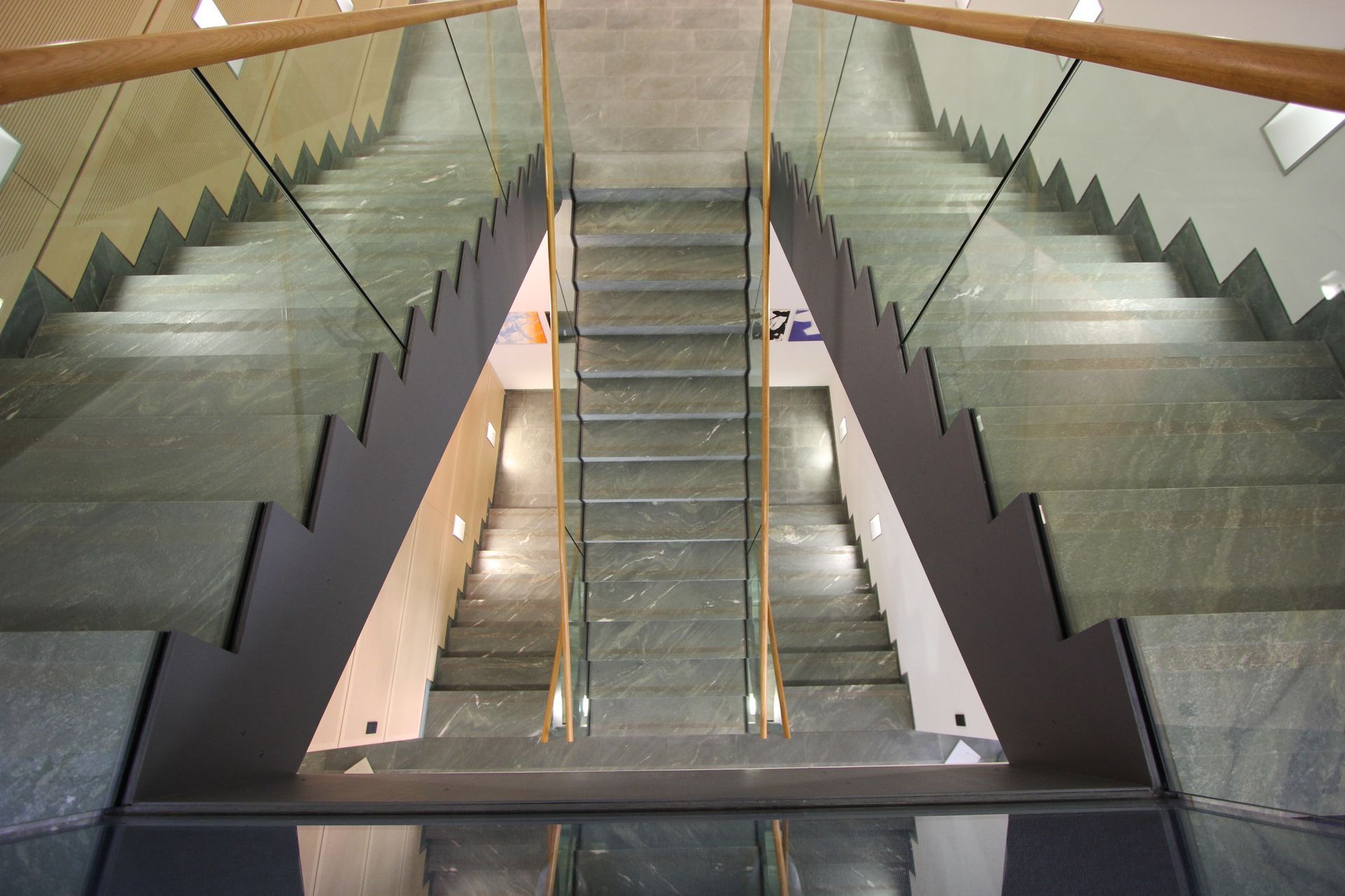 Eine Treppe mit einem Glasgeländer, das auf und ab geht